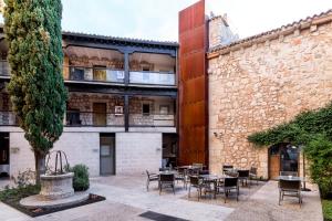 a courtyard with tables and chairs in front of a building at Parador de Alarcón in Alarcón