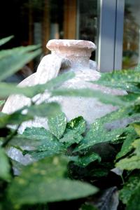 a white vase sitting next to some green plants at Hotel Milan in Pula