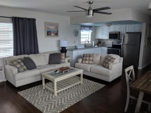 a living room with two couches and a table at Ashley Brooke Beach Resort in Deerfield Beach