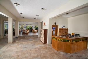 a lobby with a counter and a dining room at Hermes Hotel in Kefalos