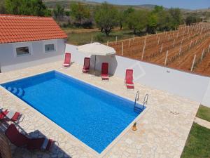 a swimming pool in front of a villa at Holiday Home Donji Lepuri in Lisičići
