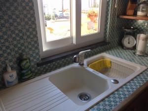 a white sink in a kitchen with a window at LA CASETTA DI ERIKA in Lacco Ameno +37 photos