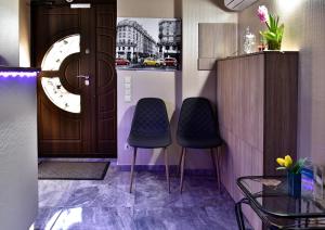 two chairs in a room with a door and a table at EXPO Hotel Comfort in Kyiv