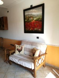 un divano in una stanza con un dipinto sul muro di Locazione Turistica Casa Vento della Toscana a Foiano della Chiana