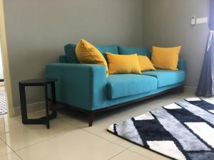Woodsbury by Micheal Butterworth Penang 7722 في بترورث: أريكة زرقاء مع وسائد صفراء في غرفة المعيشة