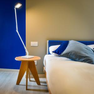a lamp on a table next to a bed at Amarina Hotel in Marina di Pietrasanta
