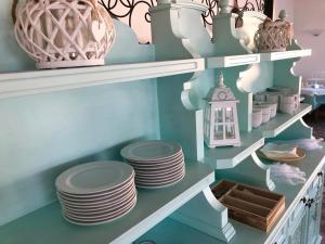 a shelf with plates and vases on it at Hotel Acquamarina in Portoferraio