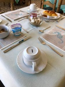 a table with a white cup and a plate on it at Hotel Acquamarina in Portoferraio