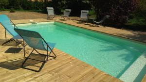 um grupo de cadeiras sentadas ao lado de uma piscina em les Ormeaux em Sauternes
