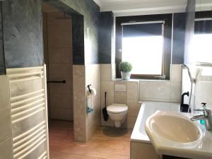 a bathroom with a toilet and a sink at 29 Haster Straße in Bad Nenndorf +22 photos