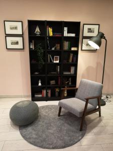 a living room with a chair and a book shelf at Hotel Impero in Rimini