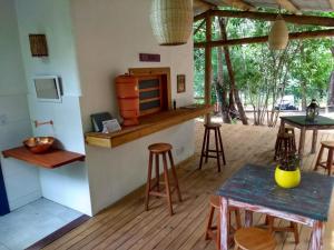 a kitchen with a counter and stools in a room at Mandacaru Guest House in Praia do Forte
