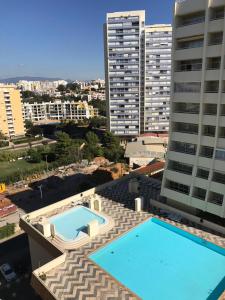 una piscina en la parte superior de un edificio con edificios altos en Acropole Algarve Beach Apartment, en Portimão