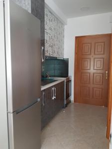 a kitchen with a refrigerator and a wooden door at The Heart of Kissamos Studios in Kissamos