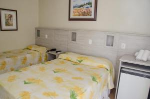 Habitación con 2 camas en una habitación en Dona Adelia Hotel e Restaurante, en Flores da Cunha