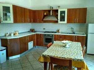 une cuisine avec des placards en bois et une table avec un chiffon de table dans l'établissement Casa Amoroso, à Santo Stefano del Sole
