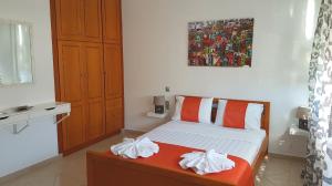 a bedroom with a bed with orange and white pillows at The Heart of Kissamos Studios in Kissamos
