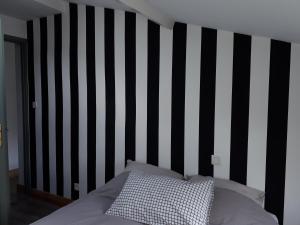 1 cama con una pared de rayas en blanco y negro en Un Appart en Ville en Niort