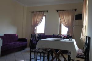 sala de estar con mesa y sofá púrpura en Ozukara Apart 2, en Gümbet