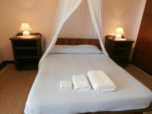 Kalogria West Peloponnese "VILLA ΜΑΝOLIA " في Áraxos: غرفة نوم عليها سرير وفوط