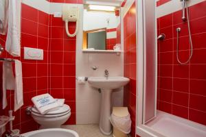 a red bathroom with a toilet and a sink at Hotel Eden in Grottammare +39 photos