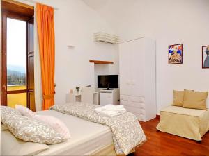 a white bedroom with a bed and a chair at B&B Villa Elisa in Meta