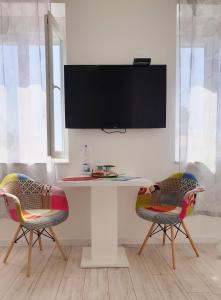 a desk with two chairs and a tv on a wall at Vila Siega in Zadar