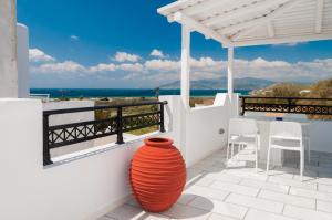 un vase orange assis sur un balcon avec vue sur l'océan dans l'établissement Villa Adriana Hotel, à Ágios Prokópios