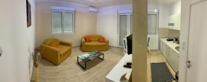 a living room with two couches and a kitchen at Airport view Apartment in Belgrade