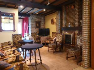 a living room with tables and chairs and a fireplace at Hostellerie Daiseldaele in Dadizele