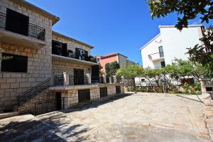 a brick building with a patio in front of it at 2 Bedrooms Apartment Margarita 4+2 in Supetar