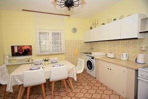 a kitchen with a table and chairs and a kitchen with yellow at 2 Bedrooms Apartment Margarita 4+2 in Supetar