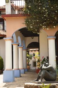 une statue d'une femme assise devant un bâtiment dans l'établissement Kukurutz Residencia, à San Cristóbal de Las Casas