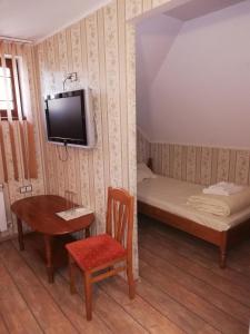 a room with a bed and a table and a tv at Комплекс Рожена, хотел, хотелски комплекс Рожена in Rozhen +114 photos