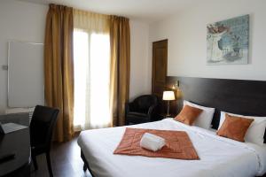 a hotel room with a bed with a towel on it at L'EPI HOTEL in Épernon