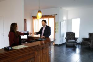 un hombre y una mujer dándose la mano en un escritorio en L'EPI HOTEL, en Épernon