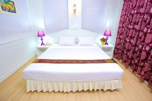 1 dormitorio con 2 camas y cortinas moradas en PJ Watergate Hotel en Bangkok