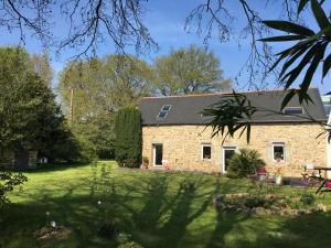 une maison en pierre avec un jardin en face dans l'établissement Kericouette et Délices, à Le Vieux-Bourg