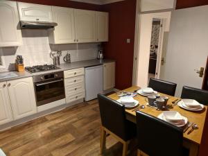 a kitchen with a wooden table with chairs and a dining room at Purbeck Escape in Wareham