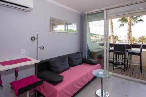 a living room with a pink couch and a table at CapSexy Port Nature Marina Naturist Village in Cap d'Agde