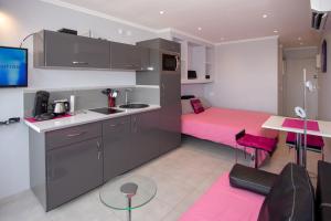 a kitchen with a pink bed in a room at CapSexy Port Nature Marina Naturist Village in Cap d'Agde +12 photos
