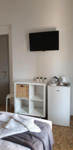 a white bedroom with a tv on the wall at Kamara rooms in Naousa in Naousa