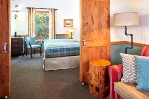 a hotel room with a bed and a couch and a bedroom at Evergreen Lodge at Yosemite in Groveland