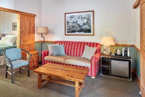 a living room with a red couch and a table at Evergreen Lodge at Yosemite in Groveland