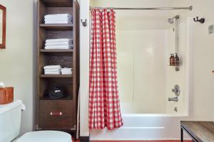 a bathroom with a shower with a red checkered shower curtain at Evergreen Lodge at Yosemite in Groveland