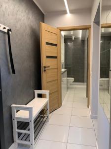 Łazienka z drewnianymi drzwiami i białą podłogą wyłożoną kafelkami w obiekcie D&M Apart Interior Styles w mieście Białystok