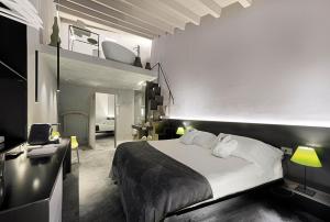1 dormitorio con 1 cama con sábanas y almohadas blancas en Locanda Don Serafino Historical Boutique Hotel, en Ragusa