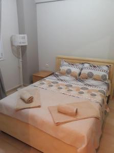 1 dormitorio con 1 cama con 2 toallas en Tassos, en Néa Michanióna
