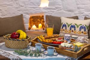 - une table avec un plateau de nourriture et une corbeille de fruits dans l'établissement Anemomylos-Windmill, à Ermoúpoli