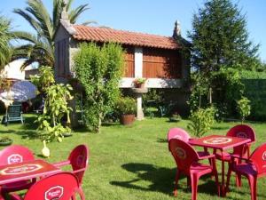 een groep rode tafels en stoelen in een tuin bij Hotel Vimar in Sanxenxo